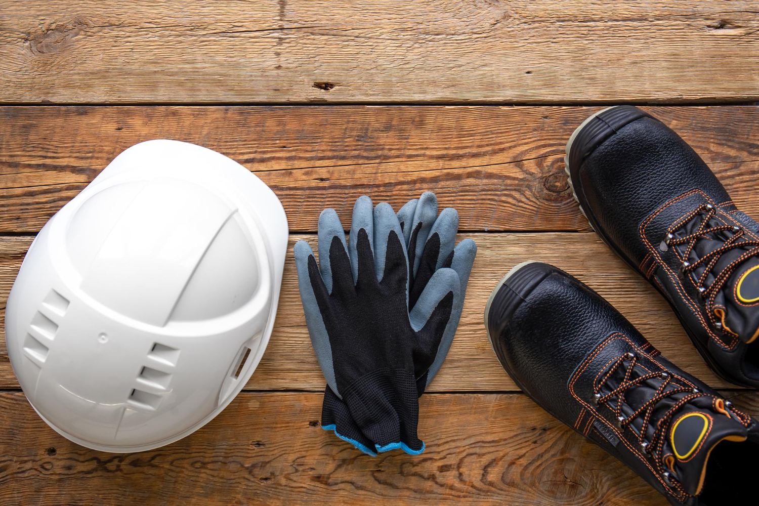 Bottes et gants de casque de travail sur une vue de dessus de fond en bois